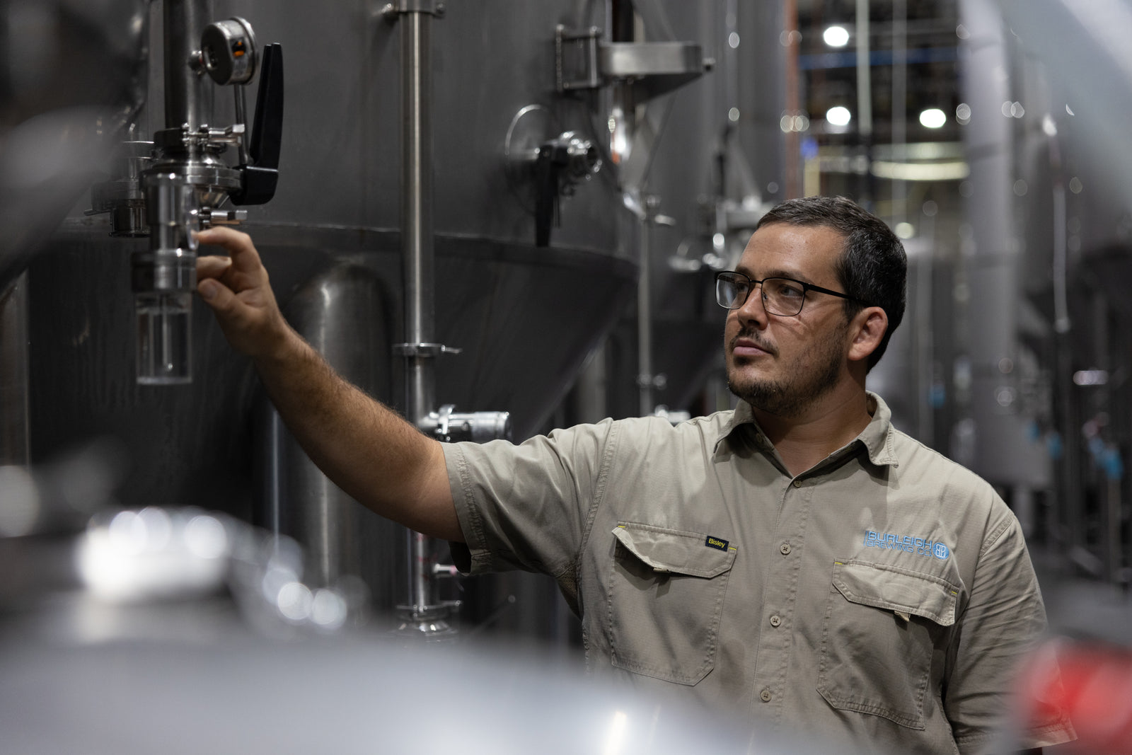 A Burleigh brewer working beside a tank